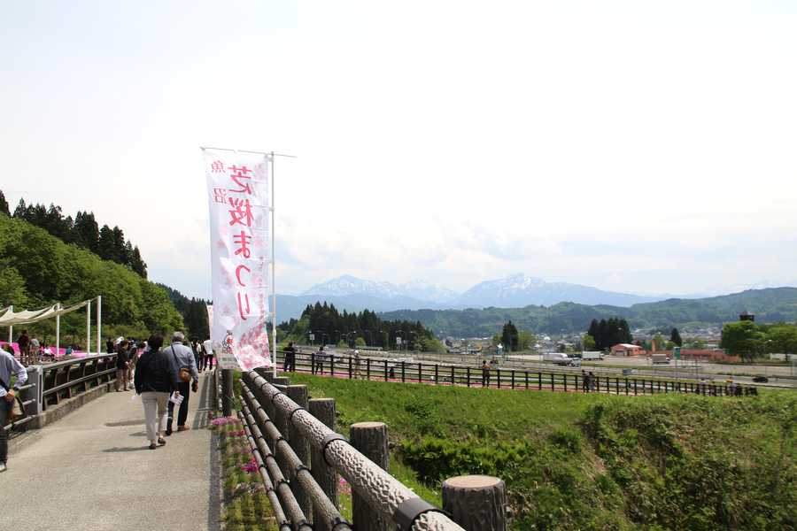 桜見橋から望む越後三山と芝桜まつりの幟旗